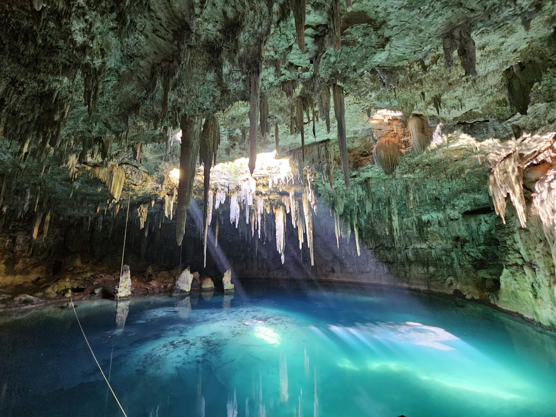 Buzo explorando cueva subacuática en un cenote de la Riviera Maya