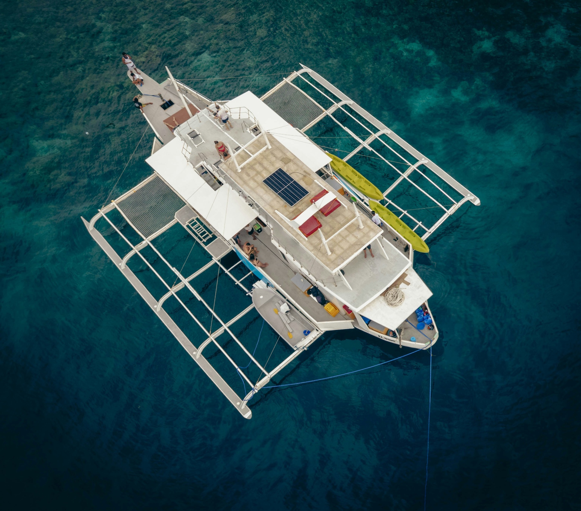Catamarán navegando hacia una isla caribeña con turistas a bordo