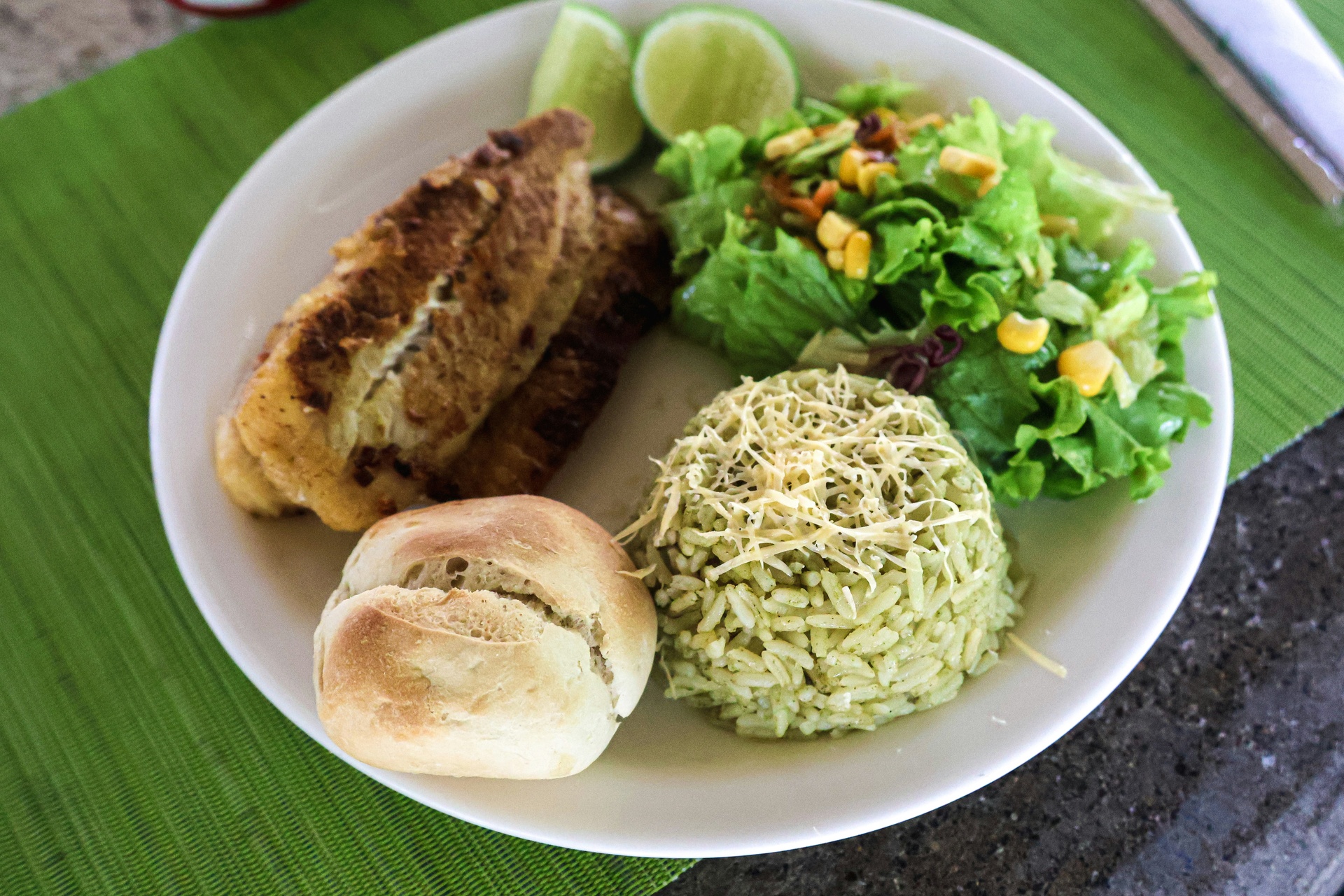 Plato de pescado a la parrilla con arroz y plátano frito en restaurante caribeño