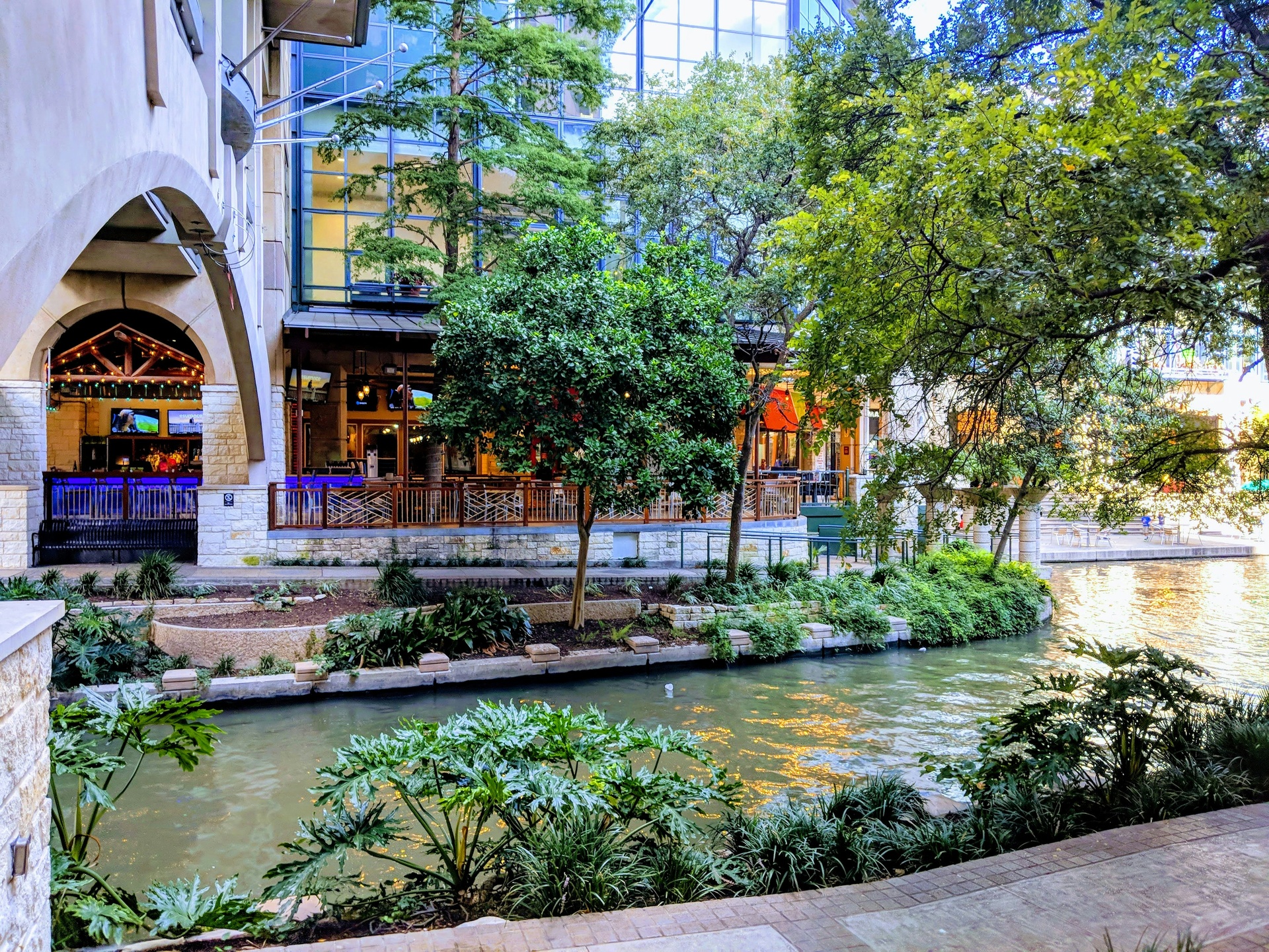 Vista del River Walk de San Antonio con botes turísticos y restaurantes a la orilla del río