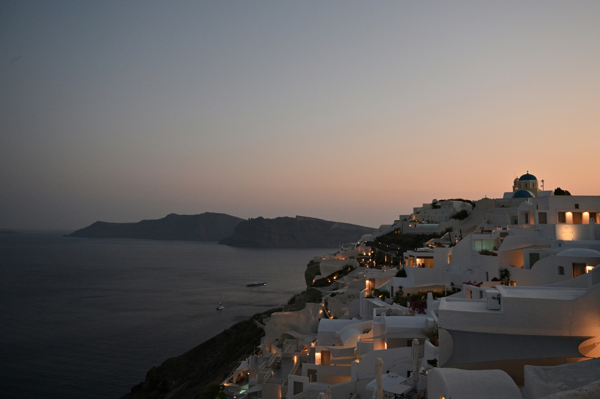 Casas blancas con cúpulas azules al atardecer en Santorini