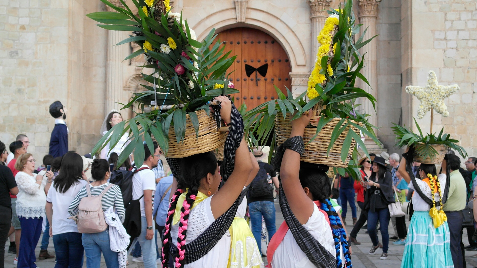 Bailarines con trajes tradicionales en una presentación de la Guelaguetza