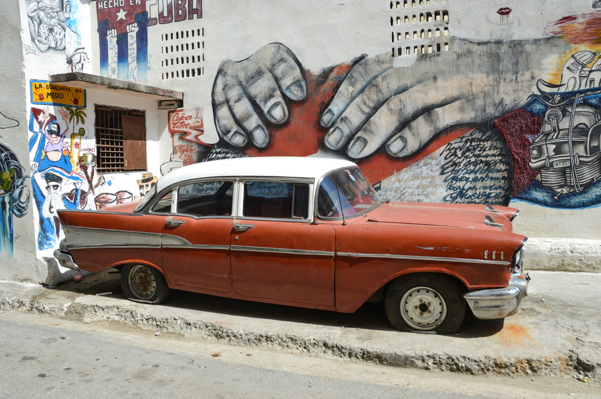 Auto clásico circulando por una calle colonial de La Habana Vieja