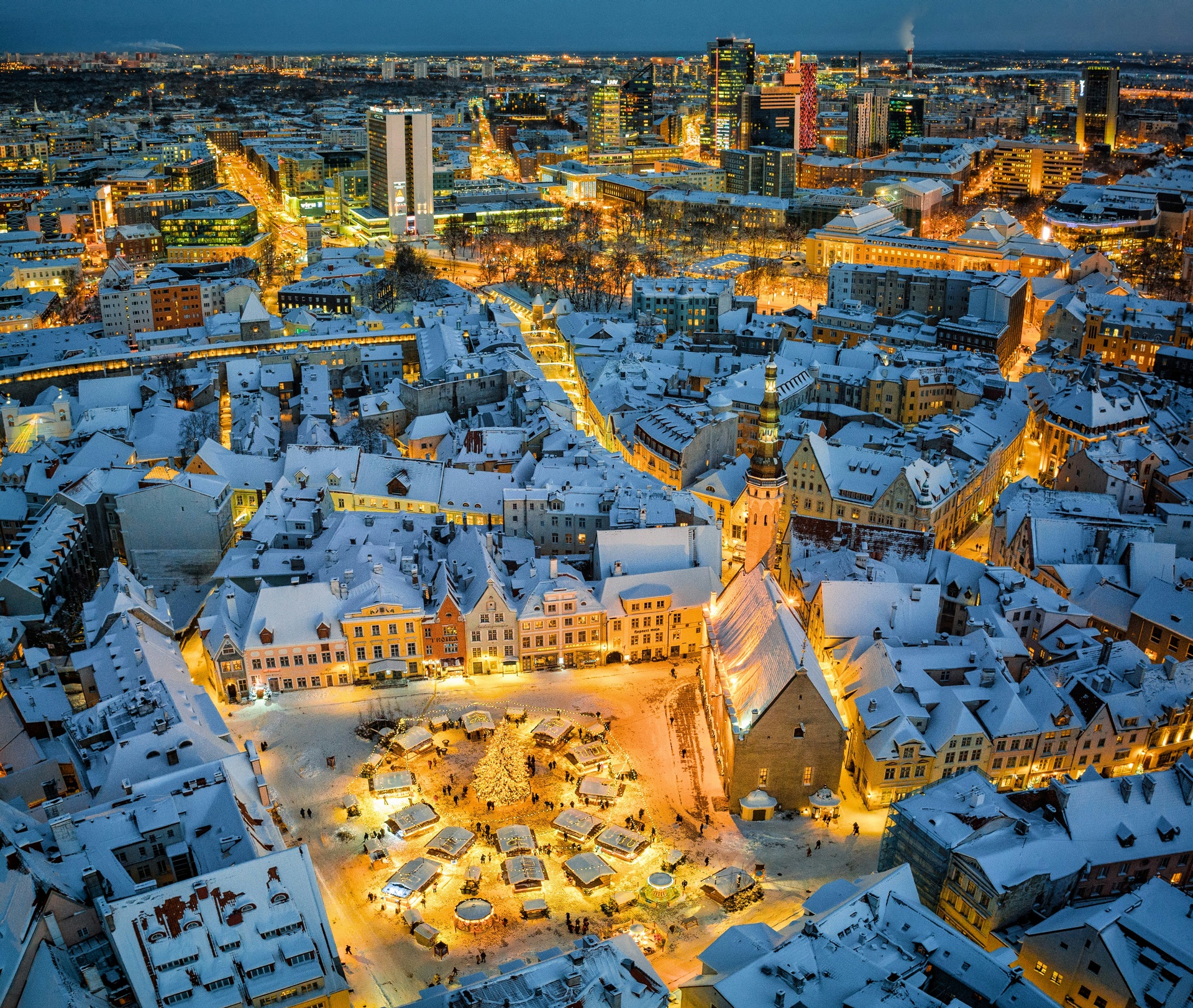Plaza medieval nevada de Tallin con árbol de Navidad iluminado